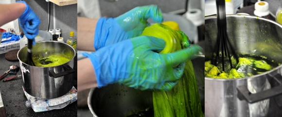 Yarn being hand-dyed green in a dye pot